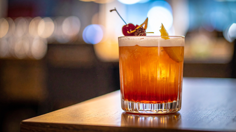 Garnished sugar free nonalcoholic cocktail in a glass with cherry and citrus peel. 