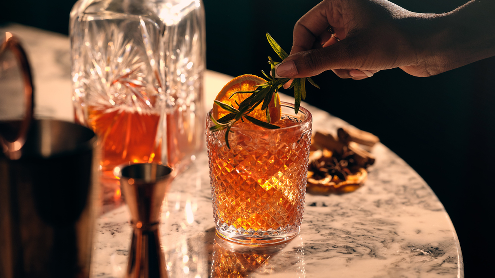 Hand Garnishing A Non Alcoholic Drink with Rosemary