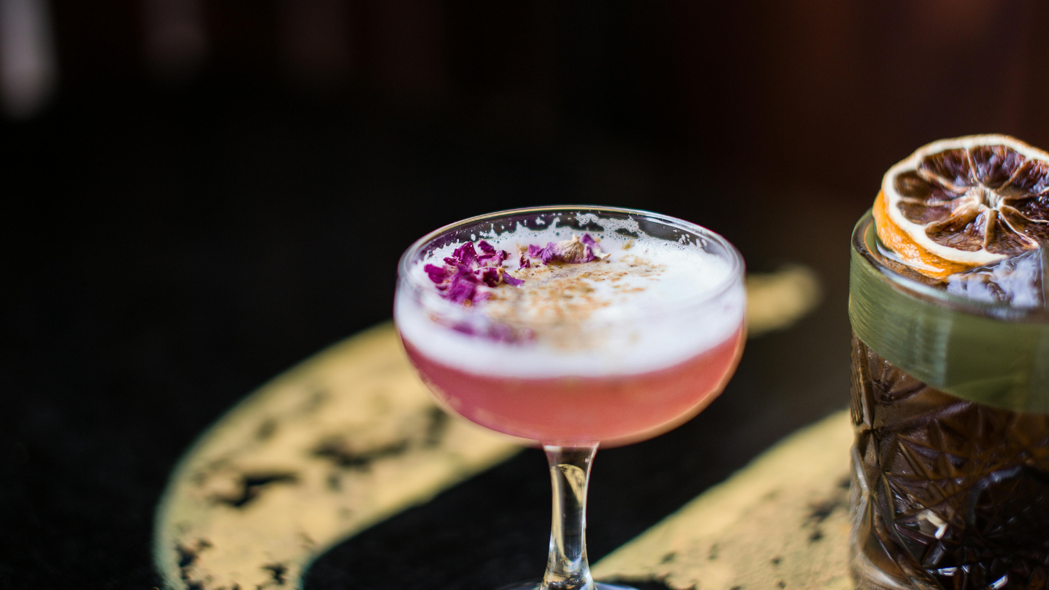 Nonalcoholic cocktail in a glass garnished with flower petals. 