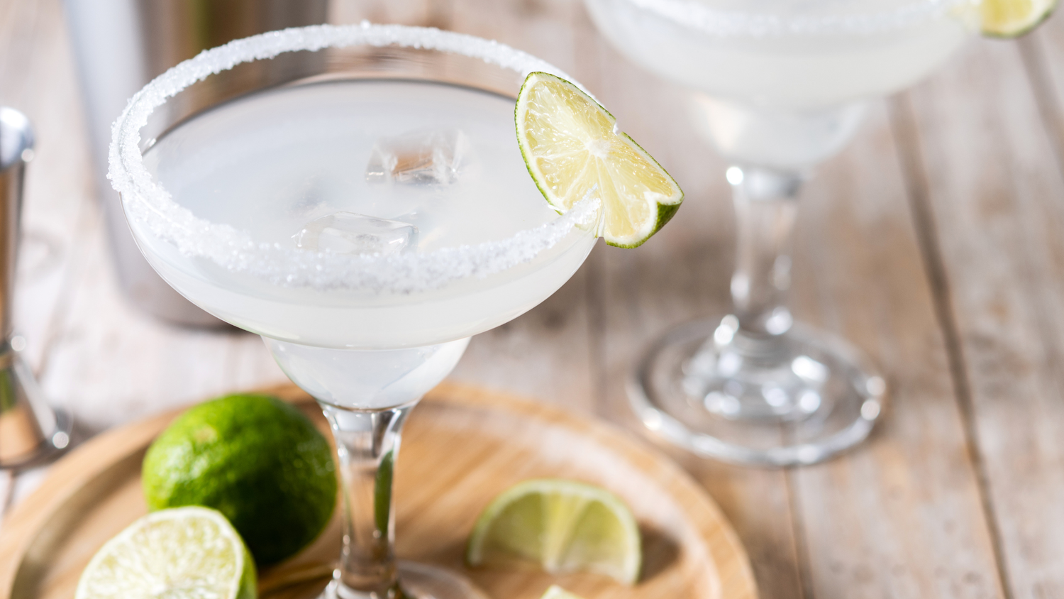 Two chilled margarita glasses with salted rims and fresh lime garnish.