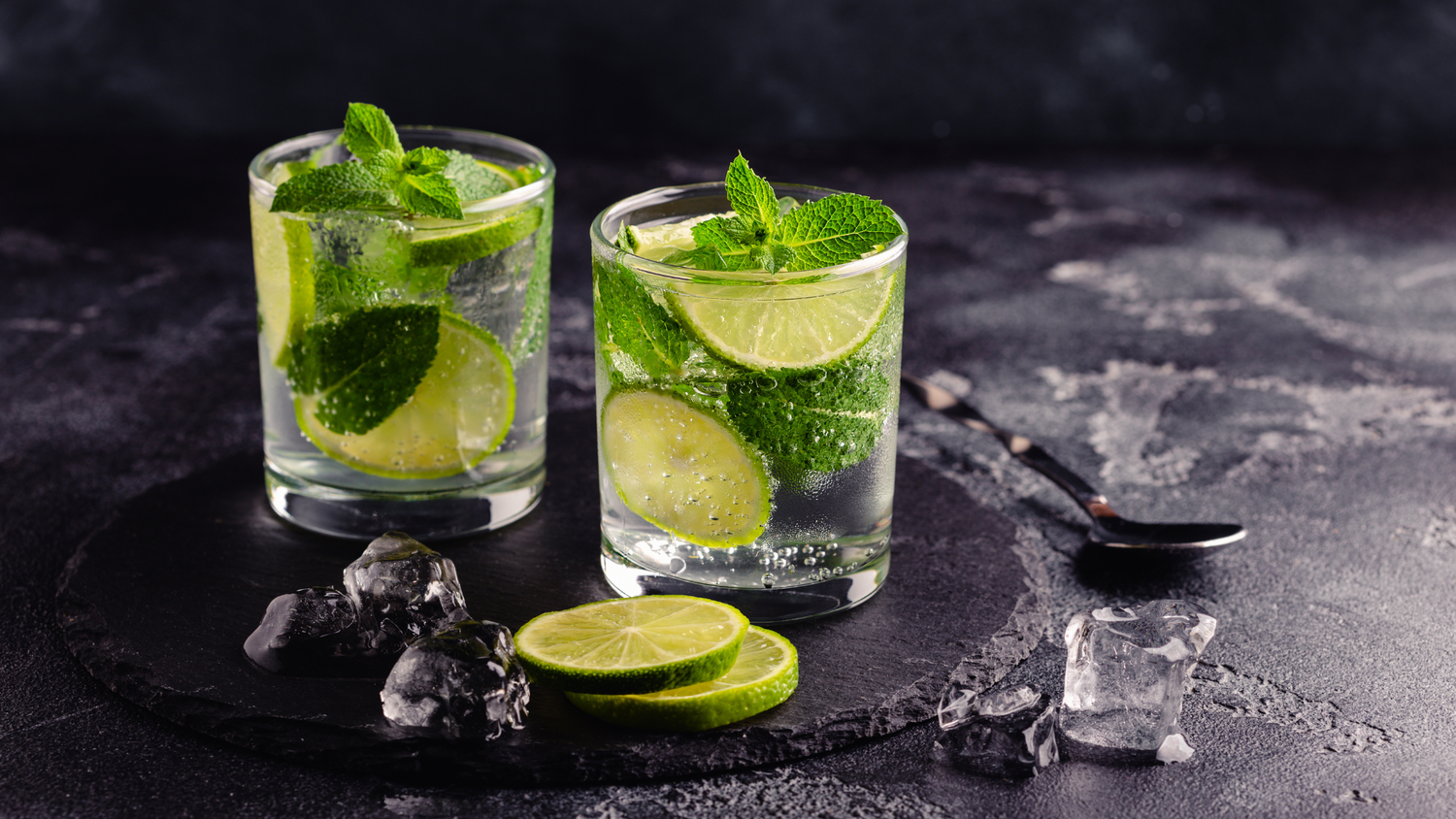 Two garnished nonalcoholic cocktails with fresh mint and lime 