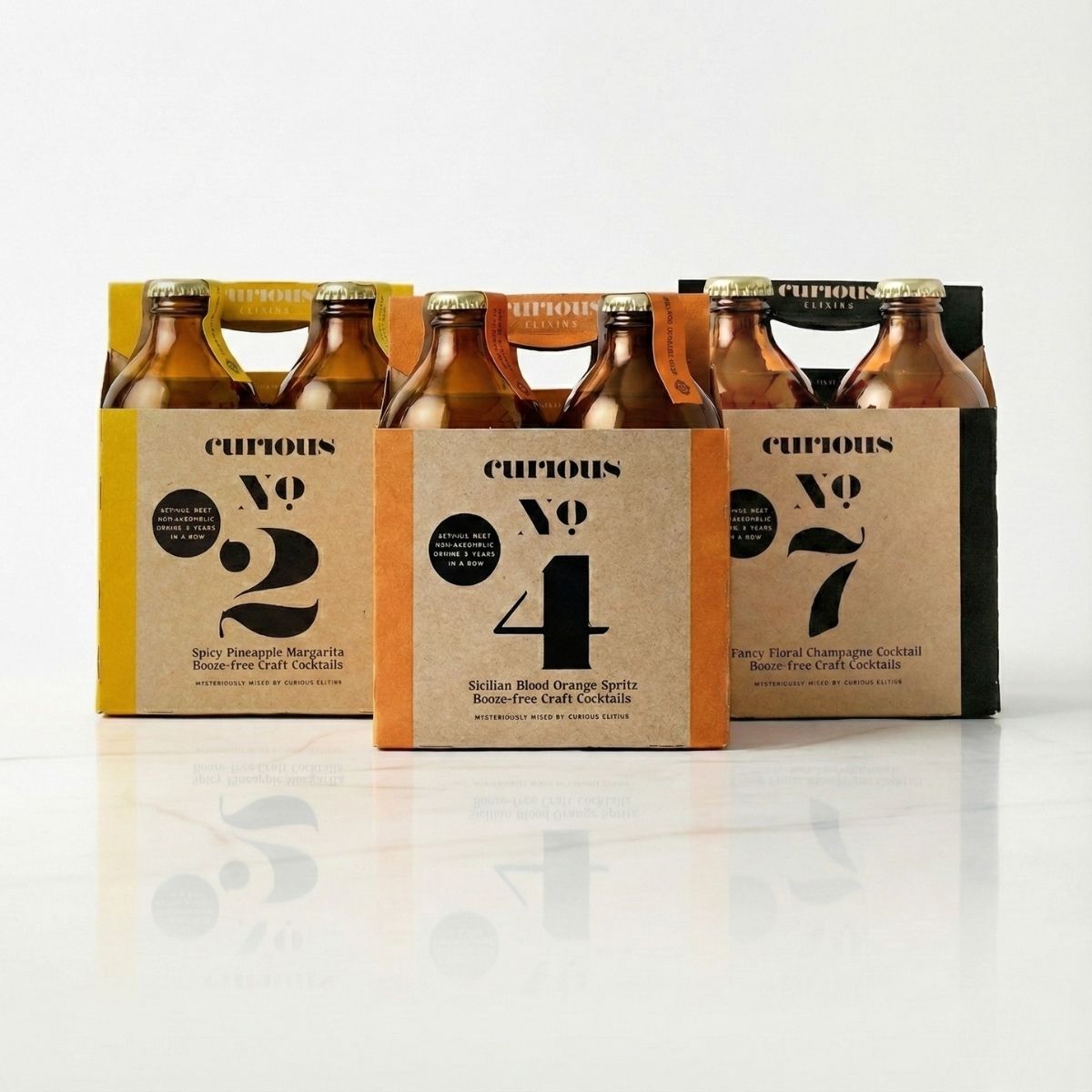 Three Curious Elixirs 4-packs displayed side by side, with No. 2 on the left, No. 4 in the center, and No. 7 on the right.