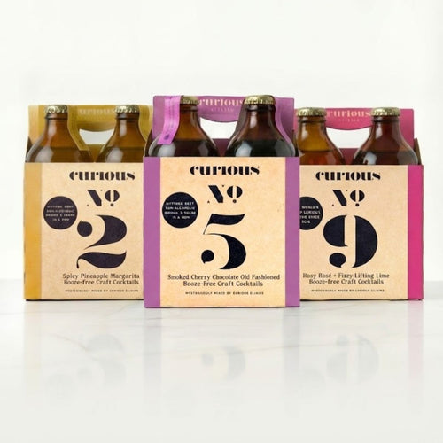 Three Curious Elixirs 4-packs displayed side by side, with No. 2 on the left, No. 5 in the center, and No. 9 on the right.