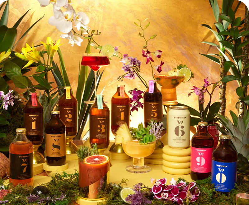 Curious Elixirs non-alcoholic cocktails styled with fresh flowers and fruit